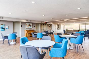 a common area with tables and chairs and a bar